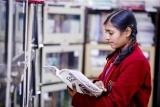 A student reading a newspaper in the library