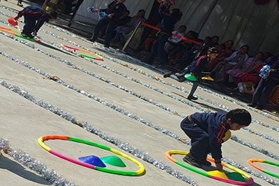 A student in a hula-hoop race on Sports Day