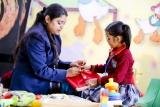 A teacher helping a young student with an activity